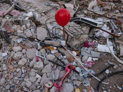 Globos rojos sobresalen de los escombros en los que murieron niños tras el terremoto de Turquía