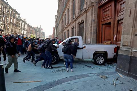 Manifestantes mexicanos derriban una puerta del Palacio Nacional con el presidente López Obrador adentro