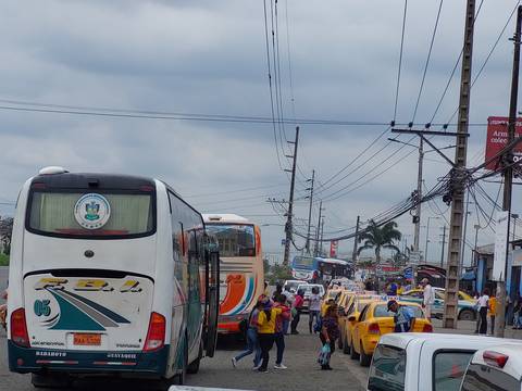 Buses dejan y reciben pasajeros en las inmediaciones de la terminal terrestre de Durán, tras ser clausurada por el Municipio 