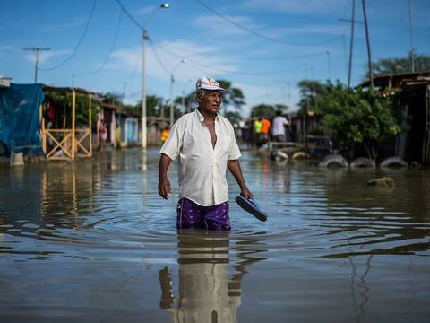 Salvavidas nadan en busca de gente en las calles inundadas de Piura
