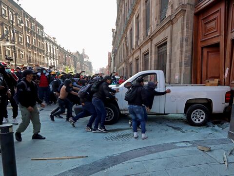 Manifestantes mexicanos derriban una puerta del Palacio Nacional con el presidente López Obrador adentro