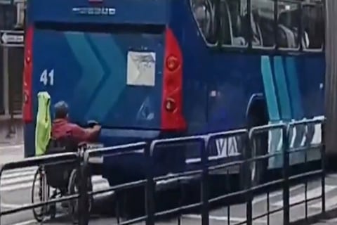 Captan a hombre en silla de ruedas circulando sujetado a un articulado de la Metrovía